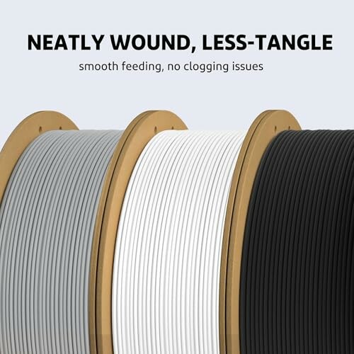 Three spools of 3D printer filament in gray, white, and black.