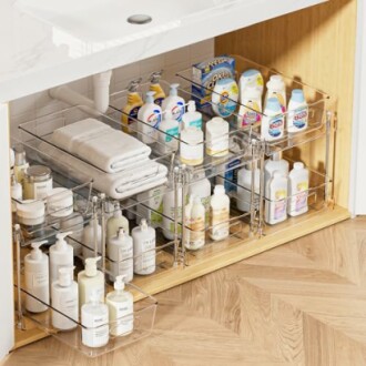 Clear storage bins with toiletries under a sink.