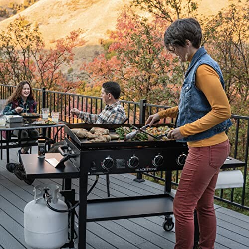 People grilling and dining on a patio with scenic view