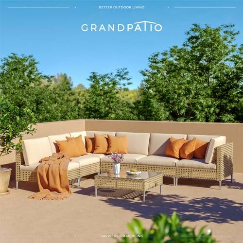 Outdoor patio furniture set with beige cushions and orange pillows on a terrace.